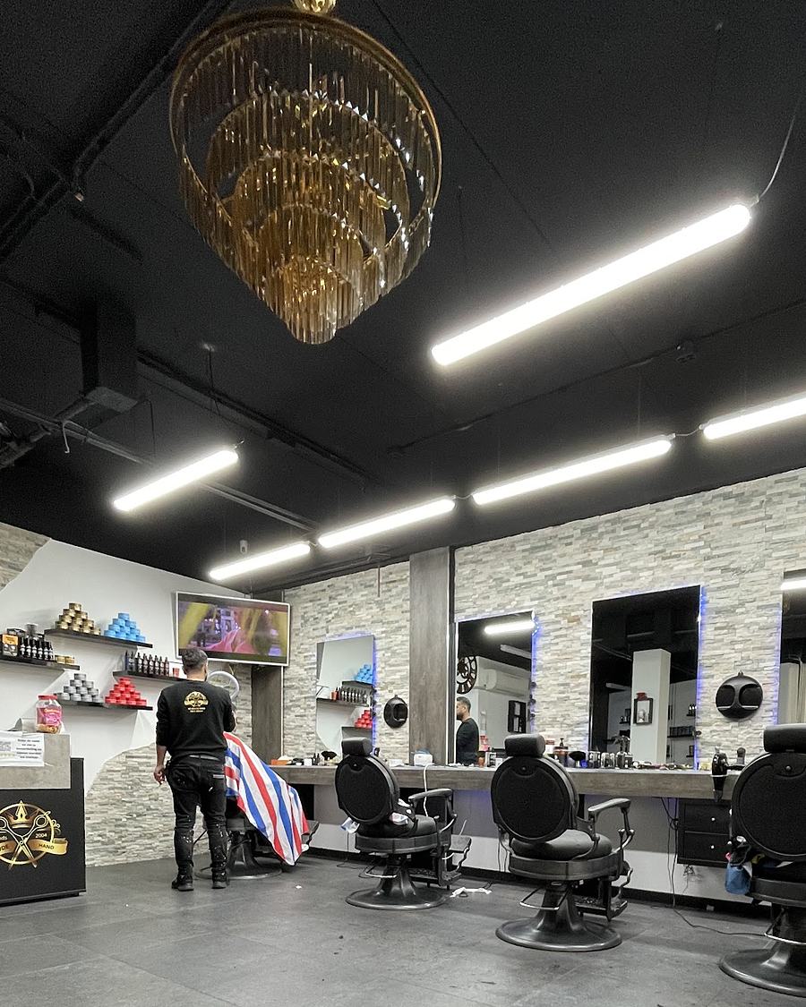 De salon van De Goude Hand met de gouden kroonluchter, zwarte stoelen en de stenen wand
